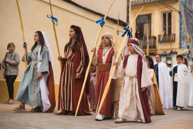 Valencia, İspanya - 24 Mart 2024: Dini kostümlü insanlar İspanya 'nın Valencia kentindeki Palm Sunday geçit törenine katıldılar
