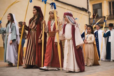 Valencia, İspanya - 24 Mart 2024: Dini kostümlü insanlar İspanya 'nın Valencia kentindeki Palm Sunday geçit törenine katıldılar