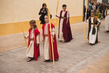 Valencia, İspanya - 24 Mart 2024: Dini kostümlü insanlar İspanya 'nın Valencia kentindeki Palm Sunday geçit törenine katıldılar