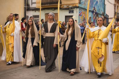 Valencia, İspanya - 24 Mart 2024: Dini kostümlü insanlar İspanya 'nın Valencia kentindeki Palm Sunday geçit törenine katıldılar