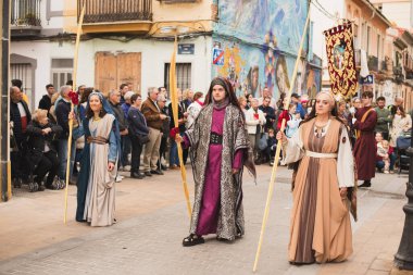 Valencia, İspanya - 24 Mart 2024: Dini kostümlü insanlar İspanya 'nın Valencia kentindeki Palm Sunday geçit törenine katıldılar