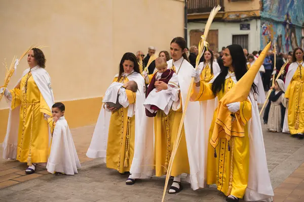 Valencia, İspanya - 24 Mart 2024: Dini kostümlü insanlar İspanya 'nın Valencia kentindeki Palm Sunday geçit törenine katıldılar