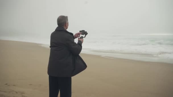 해변에서 핸드폰 지멘스를 사용하여 촬영하고 있습니다 고품질 — 비디오