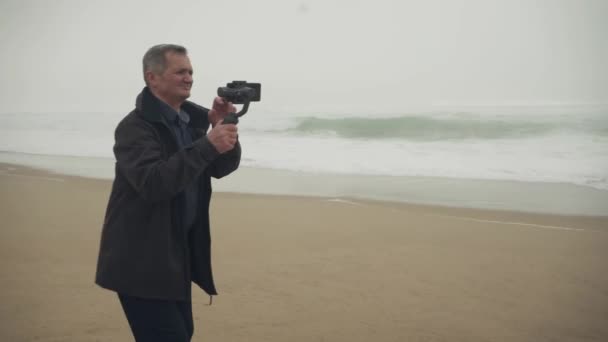 Caucasiano Sênior Filmando Praia Usando Gimbal Telefone Zoom Disparado Imagens — Vídeo de Stock