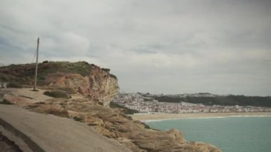 Nazare, Portekiz bulutlu bir günde. Uzun dalgalar, mavi gökyüzü, kumlu sahil. Yüksek kalite 4K görüntü