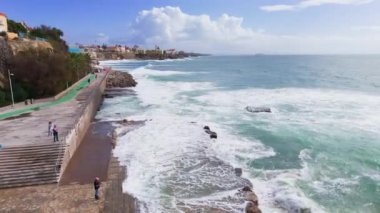 Havadan görüntü: Okyanus dalgaları huzursuzca sıçrıyor. Estoril plajı. Portekiz. Yatay hava aracı görüntüsü. 4 bin. Yüksek kalite 4k görüntü