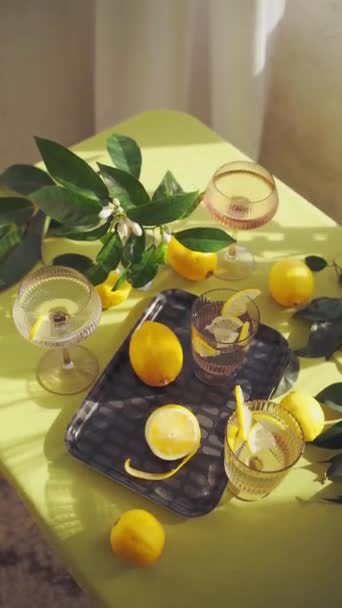 加水和柠檬的杯子 在阳光明媚的日子里 在装饰有柠檬和花朵的桌子上重新装饰健康的饮料 高质量的4K镜头 — 图库视频影像