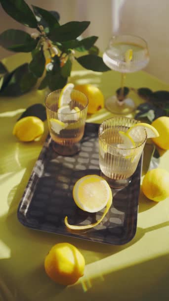 Очки Водой Лимоном Освежающие Полезные Напитки Столе Украшенном Лимонами Цветами — стоковое видео