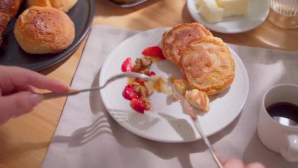 阳光灿烂的日子里 在木制桌子上享用欧陆早餐的头像 一个女人手切煎饼的特写 高质量的4K镜头 — 图库视频影像