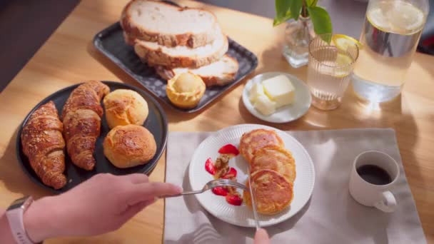 화창한 테이블에 유럽식 식사의 팬케이크를 자르는 여자의 클로즈업 고품질 — 비디오