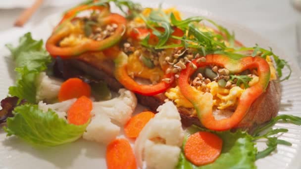 Nahaufnahme Eines Frühstückstoastes Mit Rührei Paprika Rucola Und Eingelegtem Blumenkohl — Stockvideo
