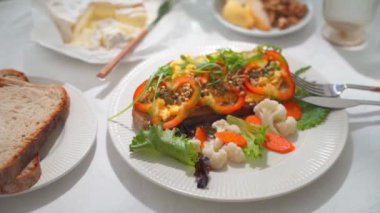 Çırpılmış yumurta, dolma biber, roka, karnabahar ve havuç turşulu kahvaltı tostu. Yüksek kalite 4K görüntü. Kamera hareketi eğiliyor