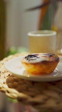 Pastel de nata ve kahve güneşli bir günde yuvarlak bir sehpada. Yakın çekim dikey video. Yüksek kalite 4k görüntü