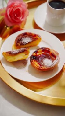 Geleneksel Portekiz tatlısı pastel de nata alan bir kadın. Yüksek kalite 4k görüntü, dikey video, pan kamera hareketi.