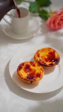  Geleneksel Portekiz tatlı pastel de nata beyaz tabakta. Yüksek kalite 4k görüntü, dikey video, kamera hareketini dikey olarak kaldır.