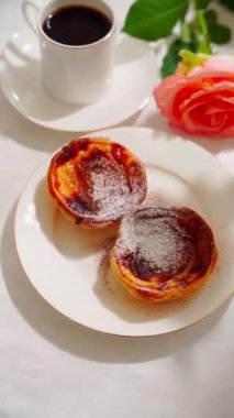  Geleneksel Portekiz tatlı pastel de nata beyaz tabakta. Yüksek kalite 4k görüntü, dikey video, kamera hareketini dikey olarak kaldır.