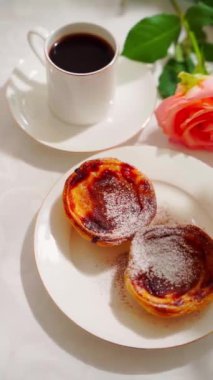  Geleneksel Portekiz tatlı pastel de nata beyaz tabakta. Yüksek kalite 4k görüntü, dikey video, pan kamera hareketi dikey video.