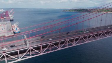 Portekiz, Lizbon 'daki Ponte 25 de Abril köprüsünde insansız hava aracı trafiği. Tagus Nehri 'nin ünlü simgesi. Portekiz 'in başkentinde güzel bir kırmızı asma köprü. Yüksek kalite 4k görüntü
