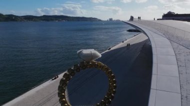 Portekiz, Lizbon 'daki Belem' deki MAAT müzesinin önünde Joana Vasconcelos 'un dev nişan yüzüğünün üzerinde uçuyor. Yüksek kalite 4k görüntü