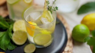 Portakal, limon ve limonla süslenmiş bir masada naneli ve kekikli iki bardak narenciyeli su. Yüksek kalite 4k görüntü