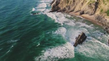 Yuvarlanan dalgaların ve kıyı boyunca oluşan kayaların hava görüntüsü. Sintra, Portekiz yakınlarındaki Atlantik kıyı şeridi. Yüksek kalite 4k görüntü