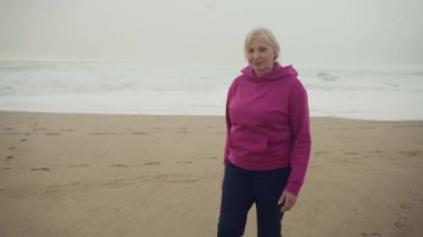 Portekiz, Cascais 'de Praia do Guincho kumsalında yürüyen son sınıf beyaz bir kadın. Yüksek kalite 4k görüntü