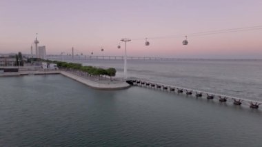 Tagus Nehri ve ikonik Vasco da Gama Köprüsü ve liman boyunca uzanan teleferiklerin yer aldığı, Lisbons Milletler Parkının parkı das Nacoes 'un hava manzarası..