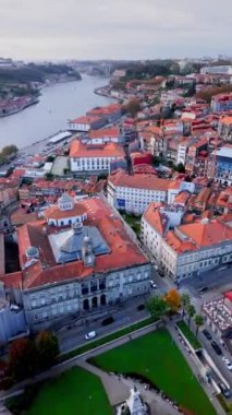 Tarihi eski Porto kasabasının üzerinde uçmak, karakteristik kırmızı çatılarını ve Douro Nehri 'ni sergilemek. Dikey video