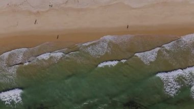 Kumsaldaki dalgaların yukarıdan aşağı görüntüsü. Vilamoura, Algarve. Yüksek kalite 4k görüntü