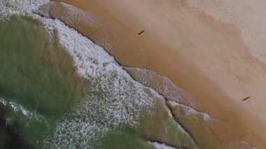 Kumsaldaki dalgaların yukarıdan aşağı görüntüsü. Vilamoura, Algarve. Yüksek kalite 4k görüntü