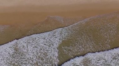 Kumsaldaki dalgaların yukarıdan aşağı görüntüsü. Vilamoura, Algarve. Yüksek kalite 4k görüntü