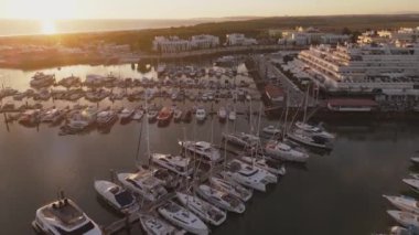 İnsansız hava aracı Vilamoura marinası boyunca uçarken altın saat arka planında şehir vardı. Portekiz 'in güneyinde, Algarve bölgesinde ünlü bir seyahat merkezi.. 