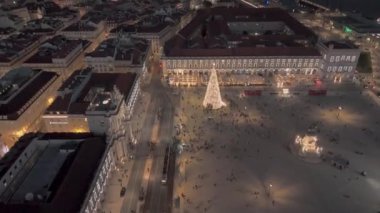 Lizbon, Portekiz - 27 Aralık 2024: Praca do Comercio 'nun yeni yıl ağacı ve eski şehir ve arka planda Tagus Nehri ile Noel ışıkları ile çekilmesi