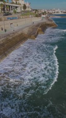 Drone gün batımında Praia do Tamariz sahilinde uçuyor. Estoril, Portekiz