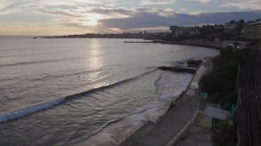 Günbatımında Praia do Tamariz 'in arka planında Cascais' in sahili çekiliyor. Estoril, Portekiz