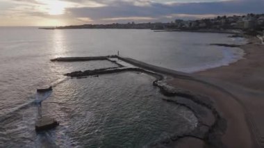 Günbatımında Praia do Tamariz 'in arka planında Cascais' in sahili çekiliyor. Estoril, Portekiz