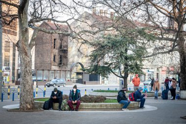BELGRAD, SERBIA - 13 Şubat 2022: Coronavirus Covid 19 krizinde maske takan Orta yaşlı erkeklerin kışın Belgrad sokaklarında oturması konusunda seçici bulanıklık