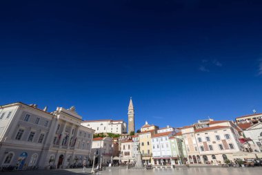 PIRAN, SLOVENIA - SEPTEMBER 17, 2021: Panorama of of the Piazza Tartini square of Piran, slovenia, with a focus on the parish church of saint george, or zupnjiska cerkev svetog jurija, a major landmark of istria