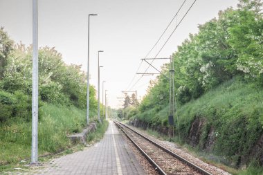 Railway tracks, rails and platforms in a suburban train station in Barajevo in Serbia, electrified, with power overhead line, on a single track main railroad line
