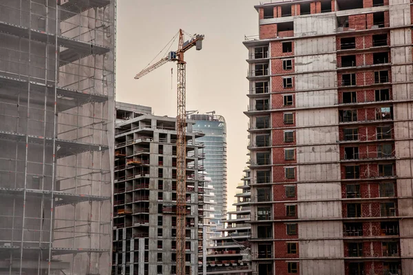 stock image Panorama of a giant Construction site of a residential building complex of skyscraper tower high rises, with scaffholdings, concrete and cement Facades as well as cranes, in a real estate development area