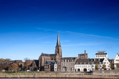 MAASTRICHT, NETHERLANDS - NOVEMBER 10, 2022: Panorama of the Maastricht Waterfront on the Meuse Maas river with a focus on the Sint Martniuskerk, a catholic church, and the ridder brewery.