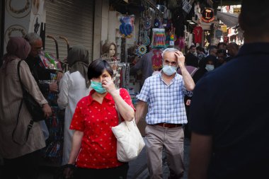 ISTANBUL, TURKEY - MAY 21, 2022: Selective blur on a senior old man and old woman walking in a crowd in istanbul, wearing a face mask in a crowd during Covid 19 Coronavirus pandemic