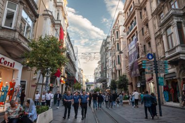 ISTANBUL, TURKEY - MAY 21, 2022: Selective blur on a turkish police patrol in front of Crowd of people, turks on Istiklal street, the main pedestrian street of beyoglu district in  Istanbul, Turkey.