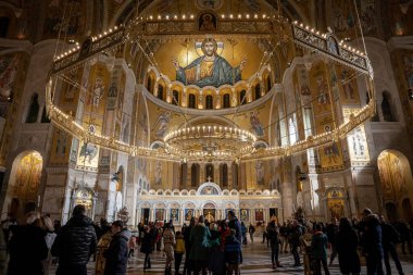 BELGRAD, SERBIA - 6 Ocak 2022: Sırbistan 'ın Belgrad kentindeki Sırp Ortodoks Kilisesi' nin karargahlarından biri olan mihrabı ve dev ikonu ile Aziz Sava Tapınağı 'nın içinde namaz kılan kalabalığın seçici bulanıklığı.