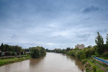 Romanya 'nın Arad kentinde soğuk bir sonbahar yağmurlu öğleden sonrasında Mures nehri ve nehir kıyısının panoraması. Arad ülkenin kuzeyinde büyük bir Romanya şehridir..