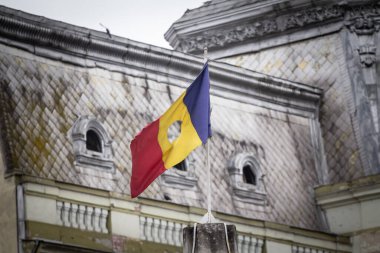 Timisoara bayrak direğinde sallanan Drapelul Romaniei adlı bir deliği olan Romen devrimci bayrağı. Romanya 'nın ulusal sembolü, 1989 Romanya devriminin komünizmi ve Çavuşesku hükümdarlığını sona erdiren amblemi..