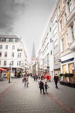 BONN, GERMANY - 7 Kasım 2022: Batı Almanya 'da Bonn şehir merkezinin bir caddesi olan Remigiusstrasse Caddesi' ndeki mağazaların ve dükkanların önünden geçen bir kalabalık.