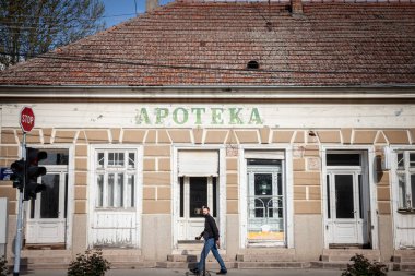 BELA CRKVA, SERBIA - APRIL 23, 2022: Abandoned and closed pharmacy in Serbia, in Bela Crkva, in a region hit by rural exodus and emigration in balkans, impacting the local medical healthcare system. clipart