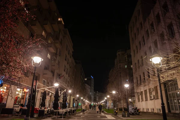 stock image BELGRADE, SERBIA - DECEMBER 25, 2022: People walking and sitting, on the pedestrian street of Obilicev Venac during a winter evening, in Stari Grad, the historical downtown center of belgrade.