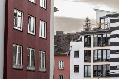 Typical residential street with contemporary multistorey residential buildings in a suburban street of Aachen, germany, being developed for real estate in a Western European background. clipart